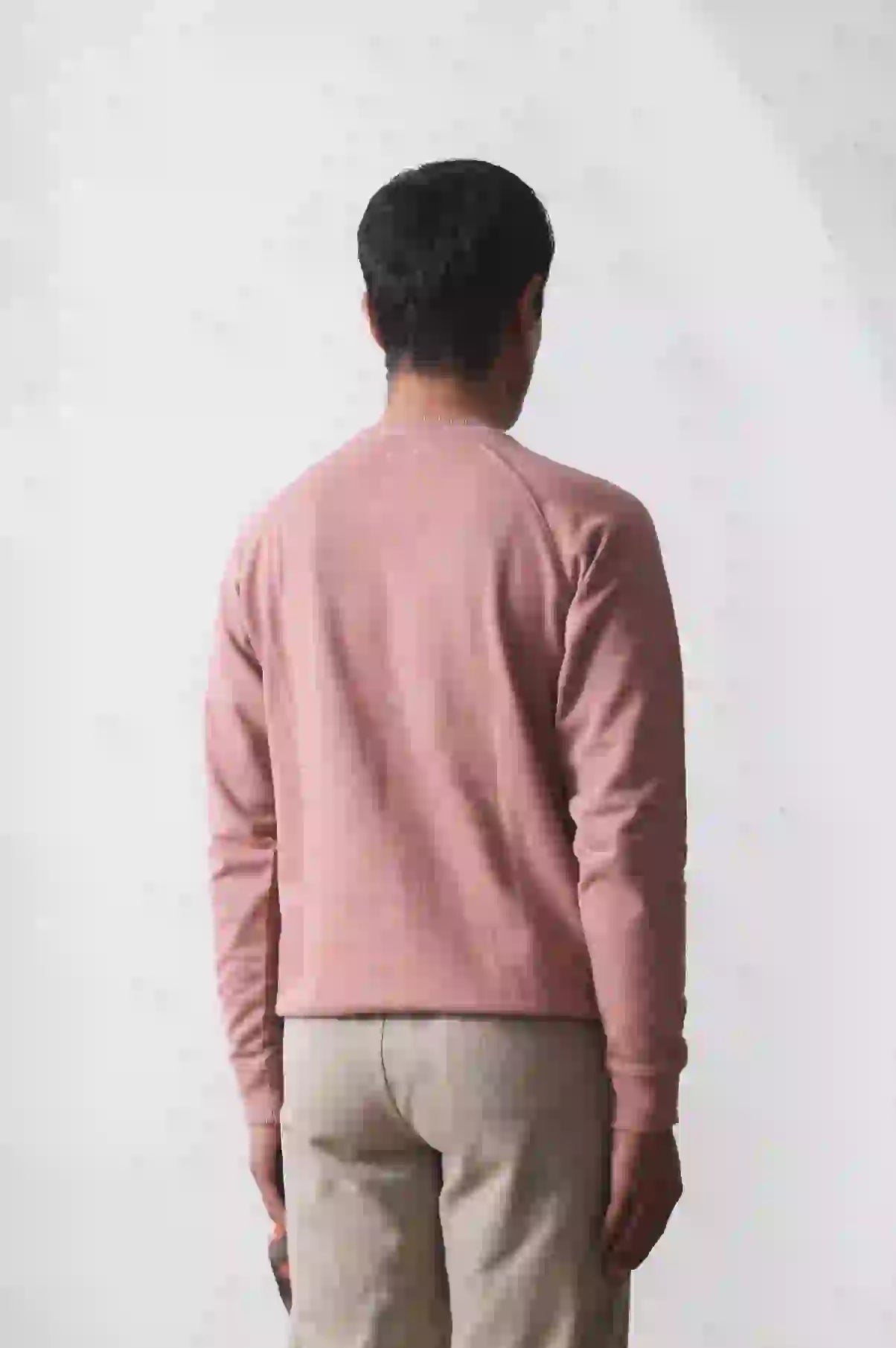 A back shot of man wearing old rose shirt