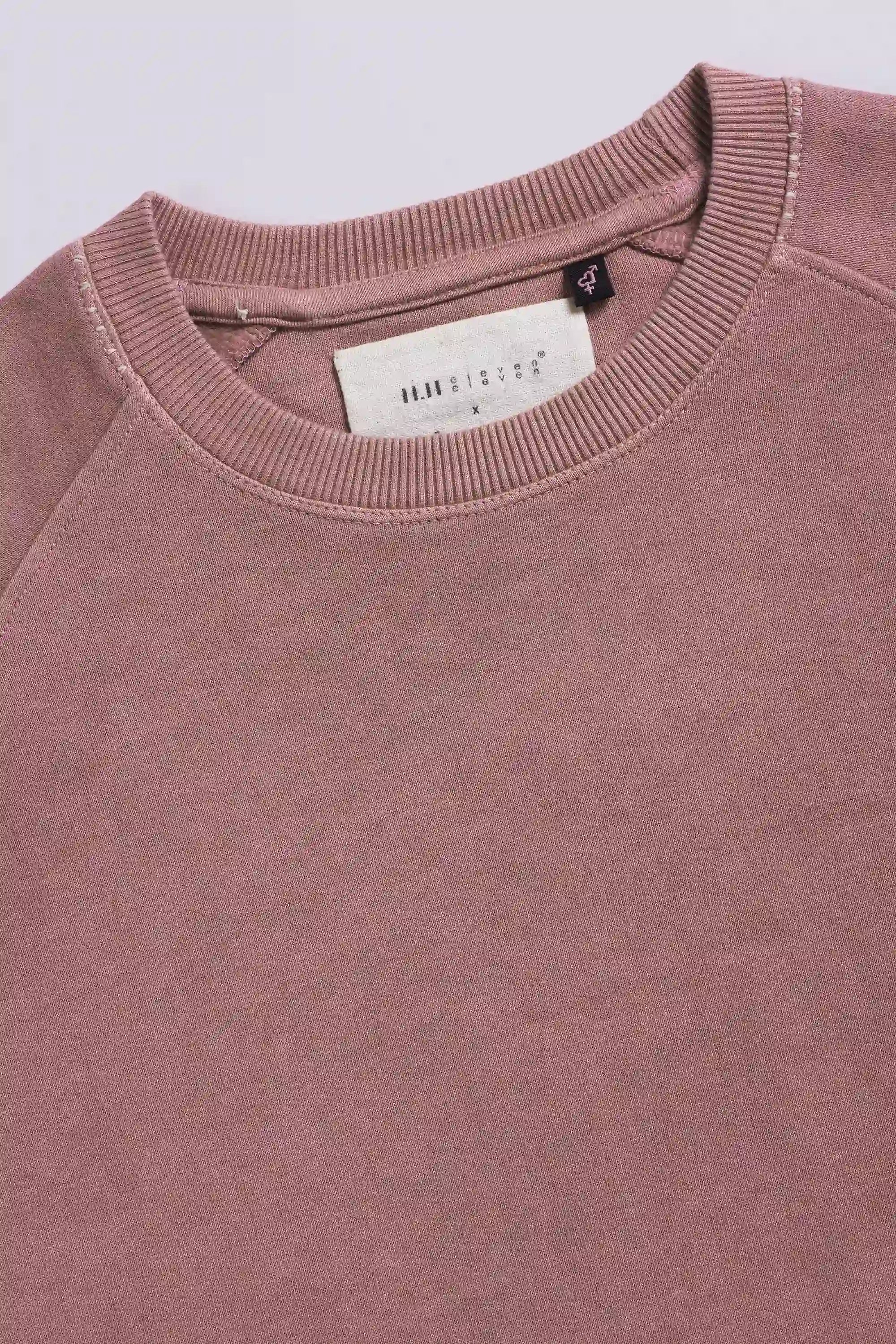 Close-up of a  sweatshirt with a brand label on a light grey background