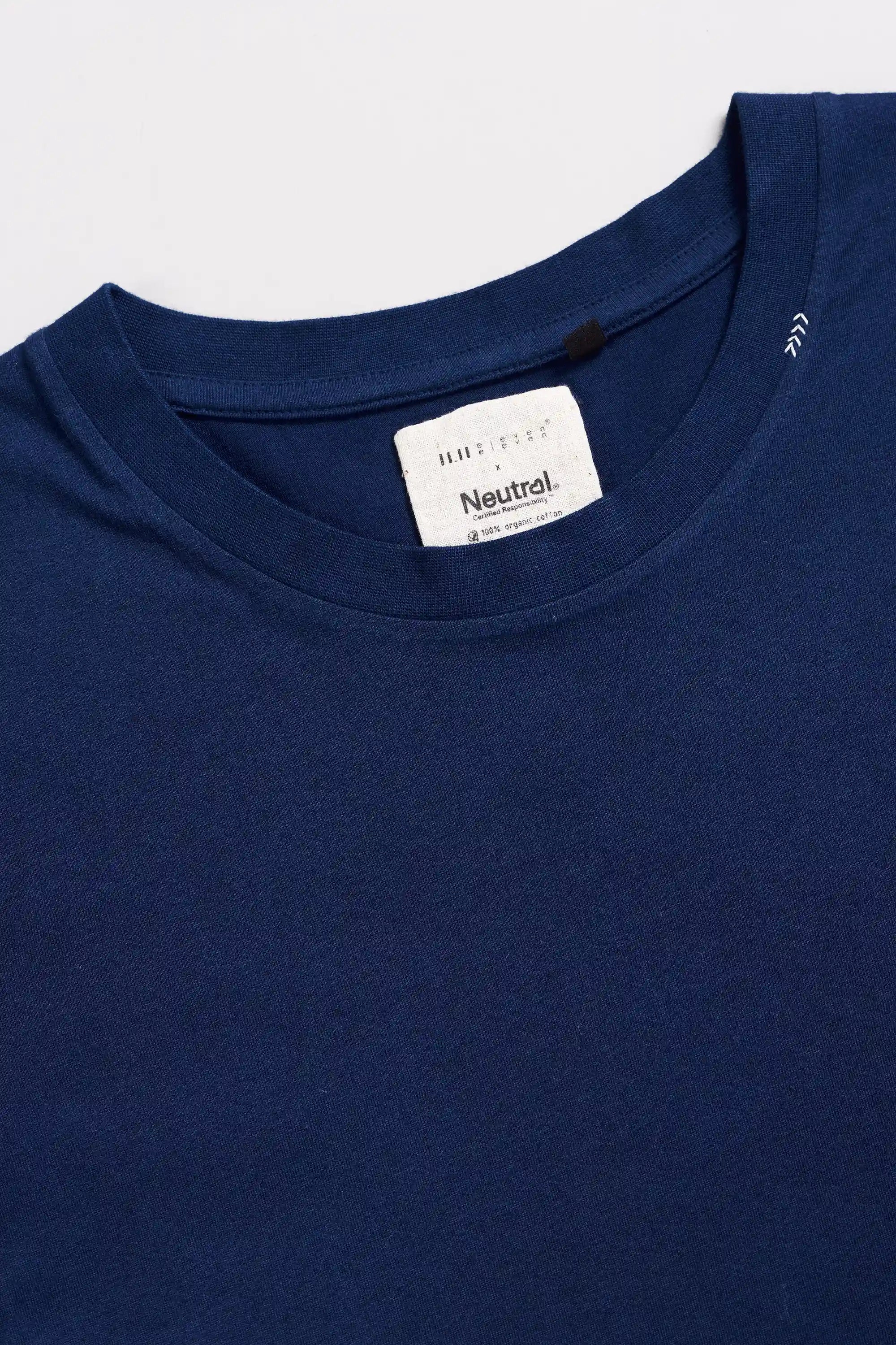 Close-up of a blue t-shirt with hand detail on a light grey  background
