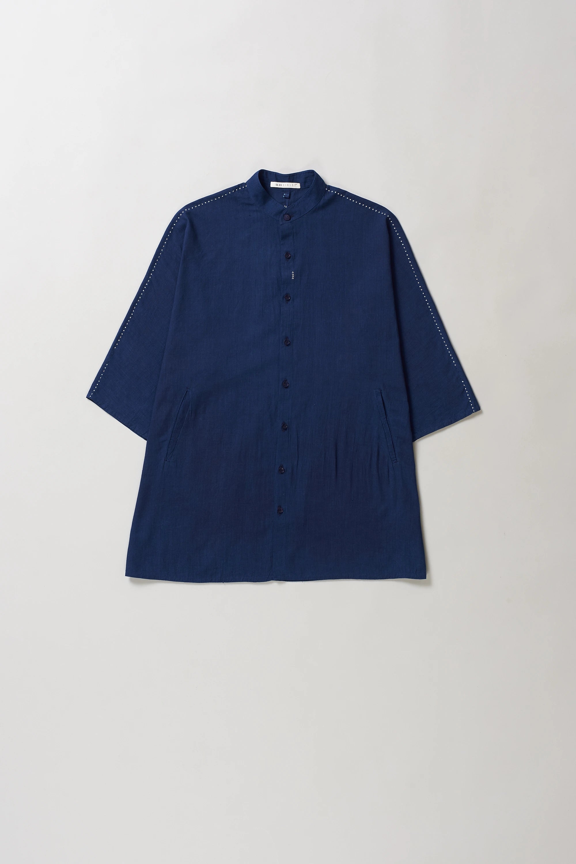Front image of blue shirt with hand detailing on a light grey background