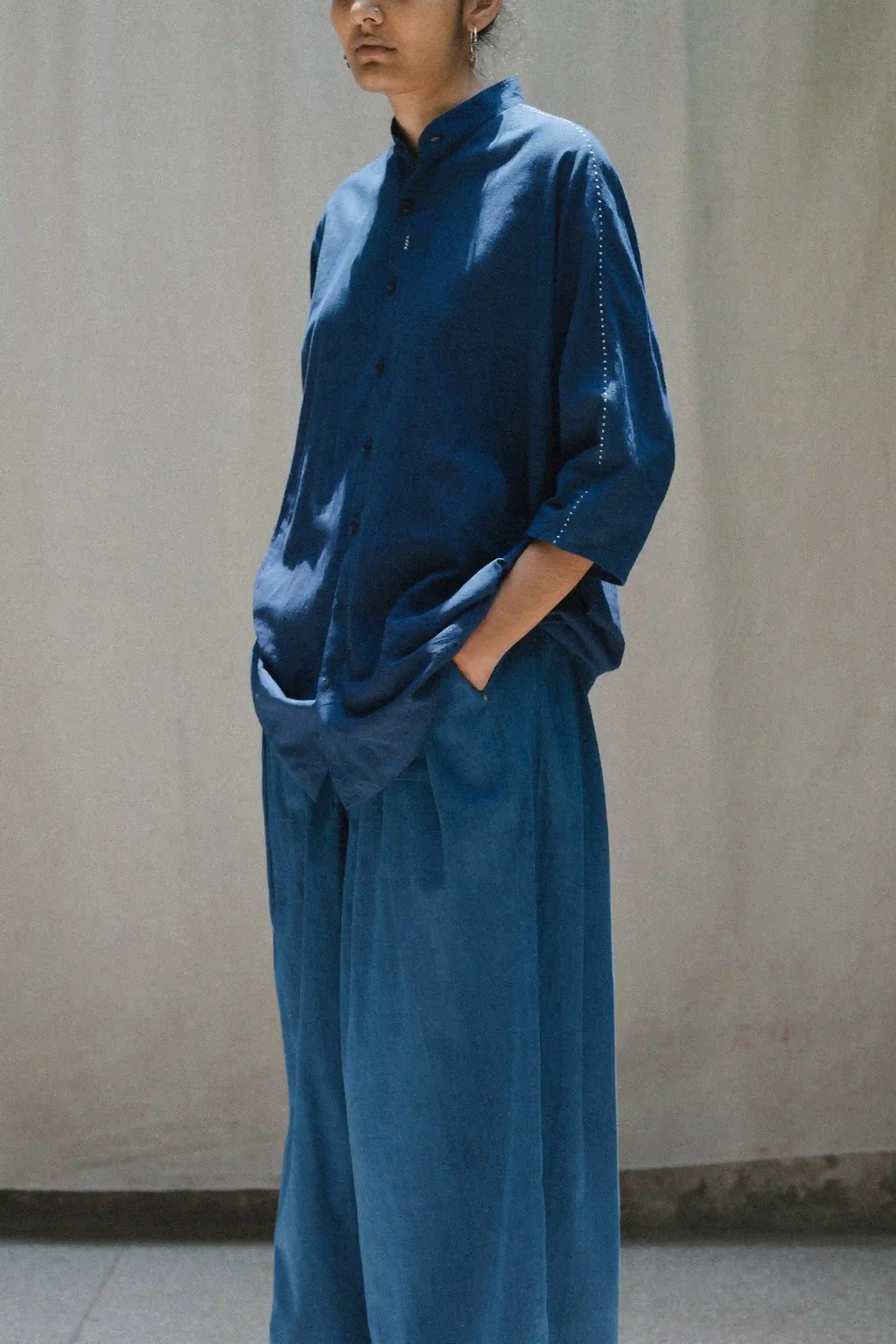 Woman wearing a blue outfit against a plain background