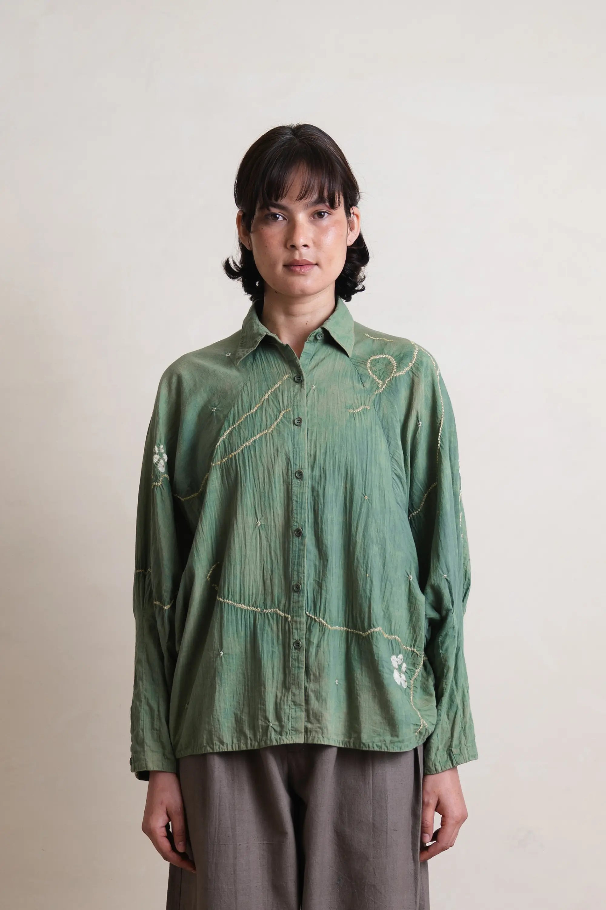 A woman wearing turf green shirt