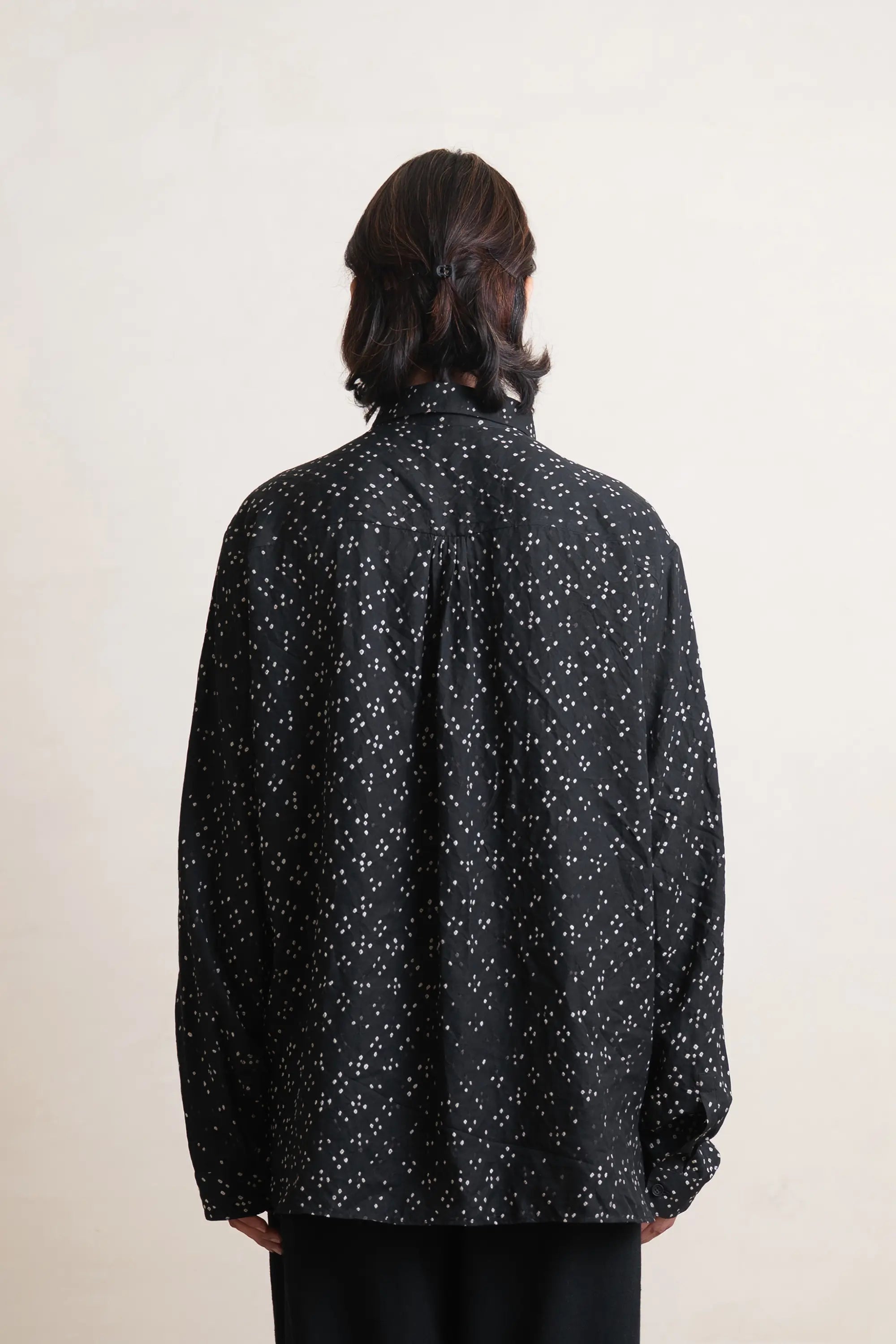 A back shot of woman wearing black silk shirt