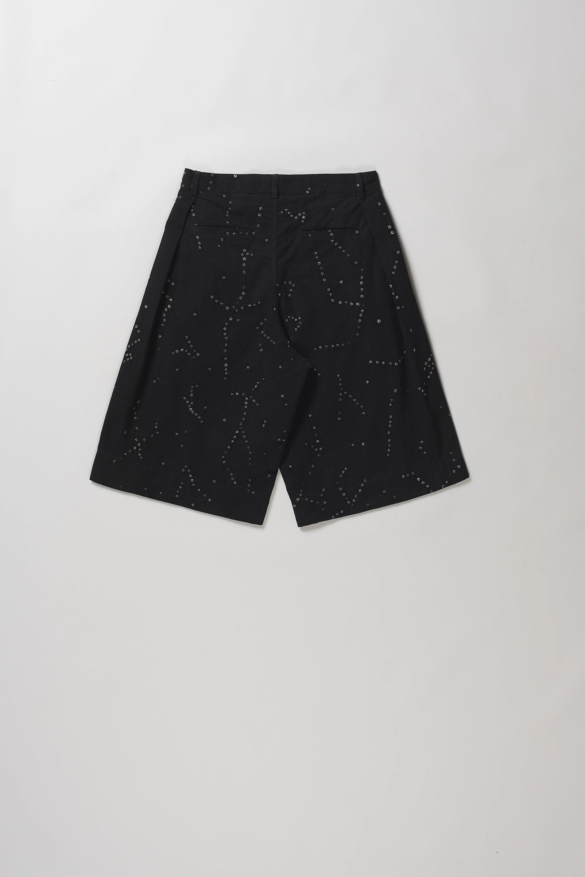 Black shot of back wide-leg shorts with a subtle white speckled constellation pattern, laid flat on a light grey background.