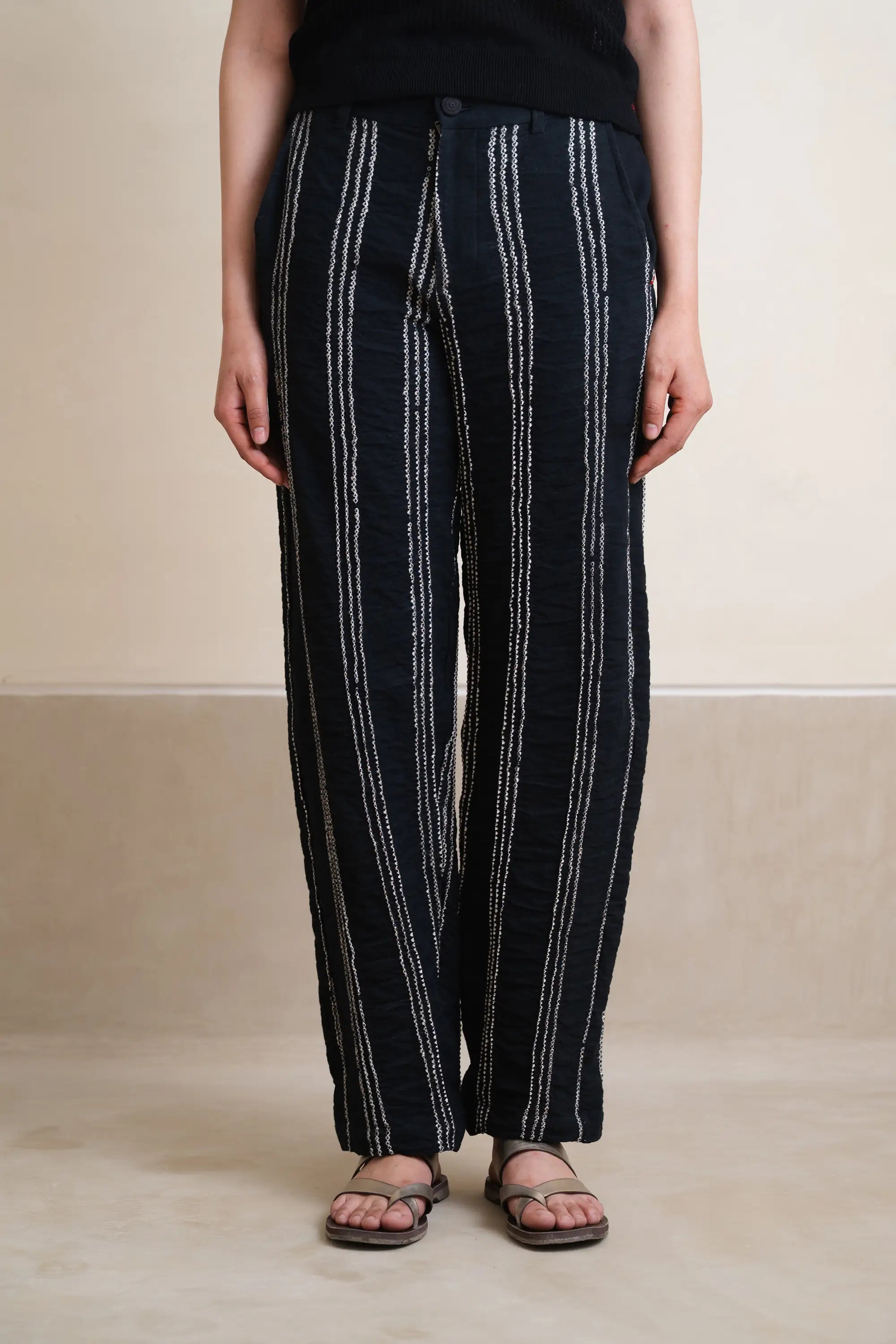 Woman wearing black pants with white stripes on a beige background