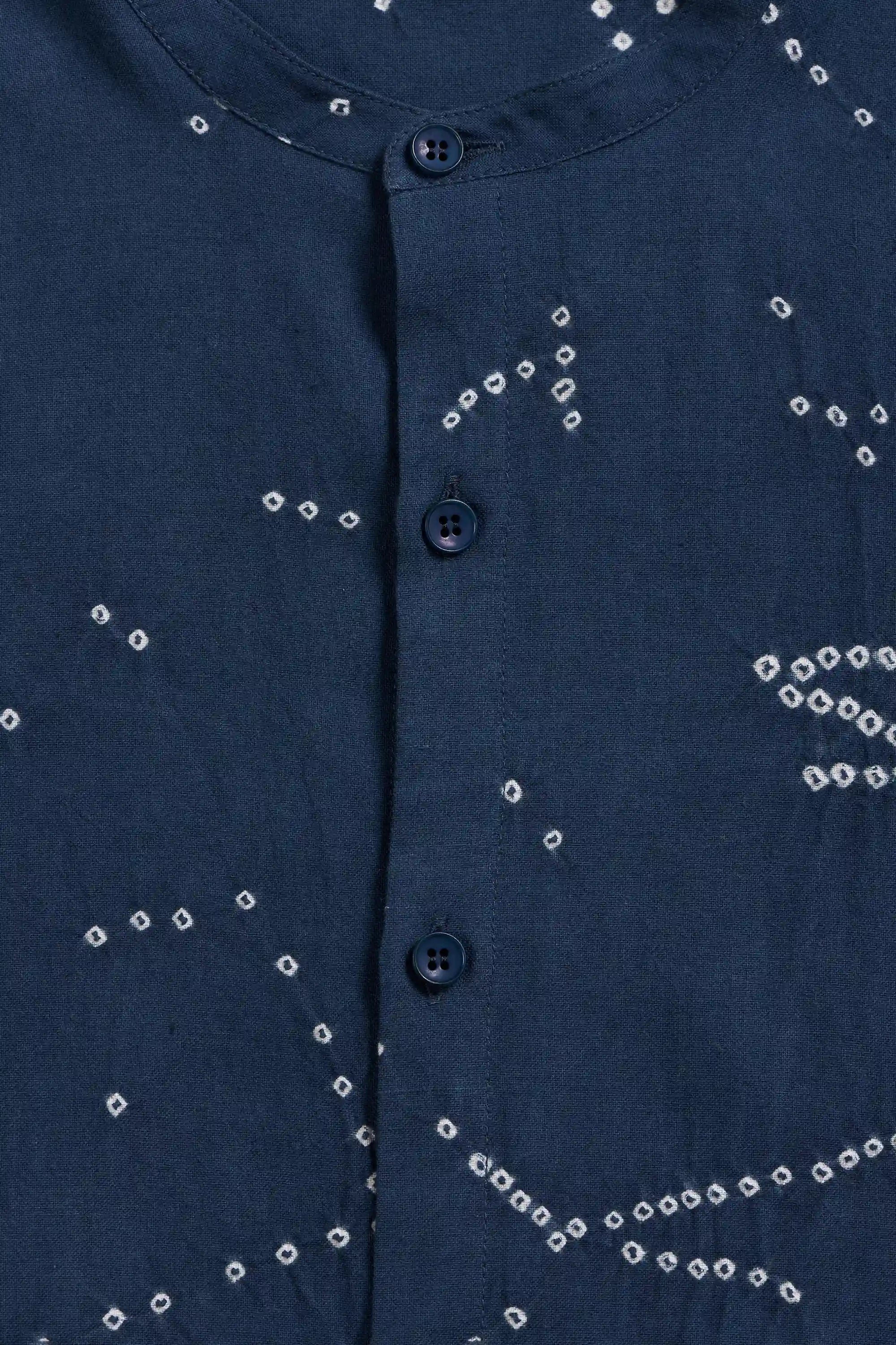 Close-up of a space blue button-up shirt with white tie-dye style dot patterns scattered across the fabric.