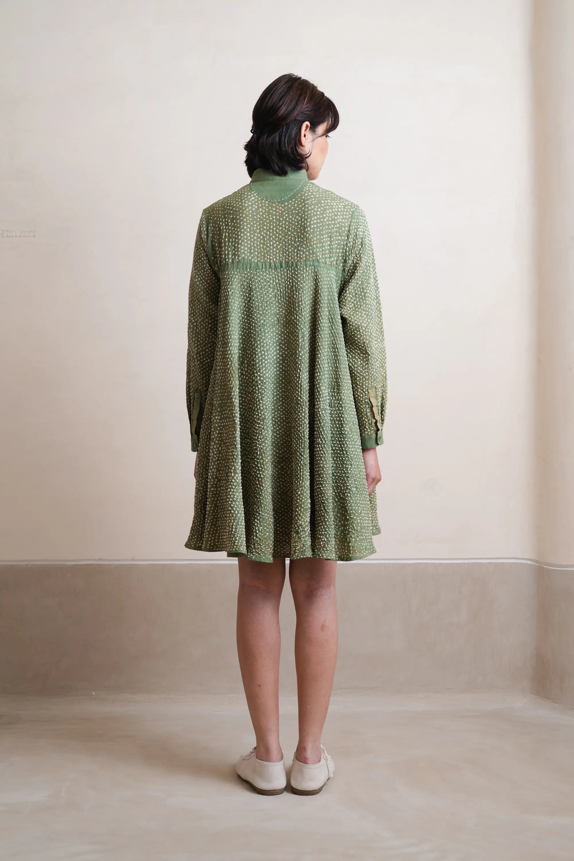 Back shot of women model wearing a turf green dress with grey background