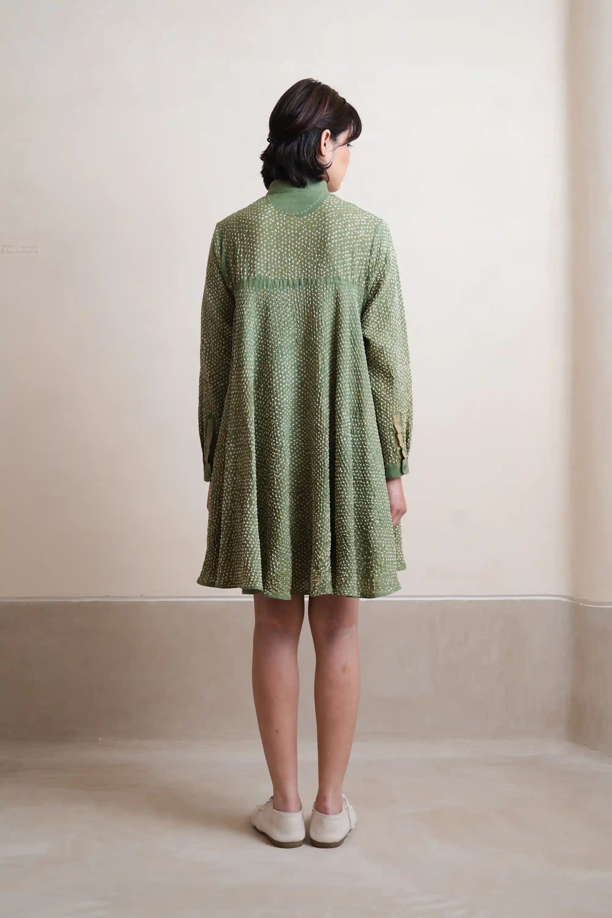 A back shot of woman wearing turf green cotton dress