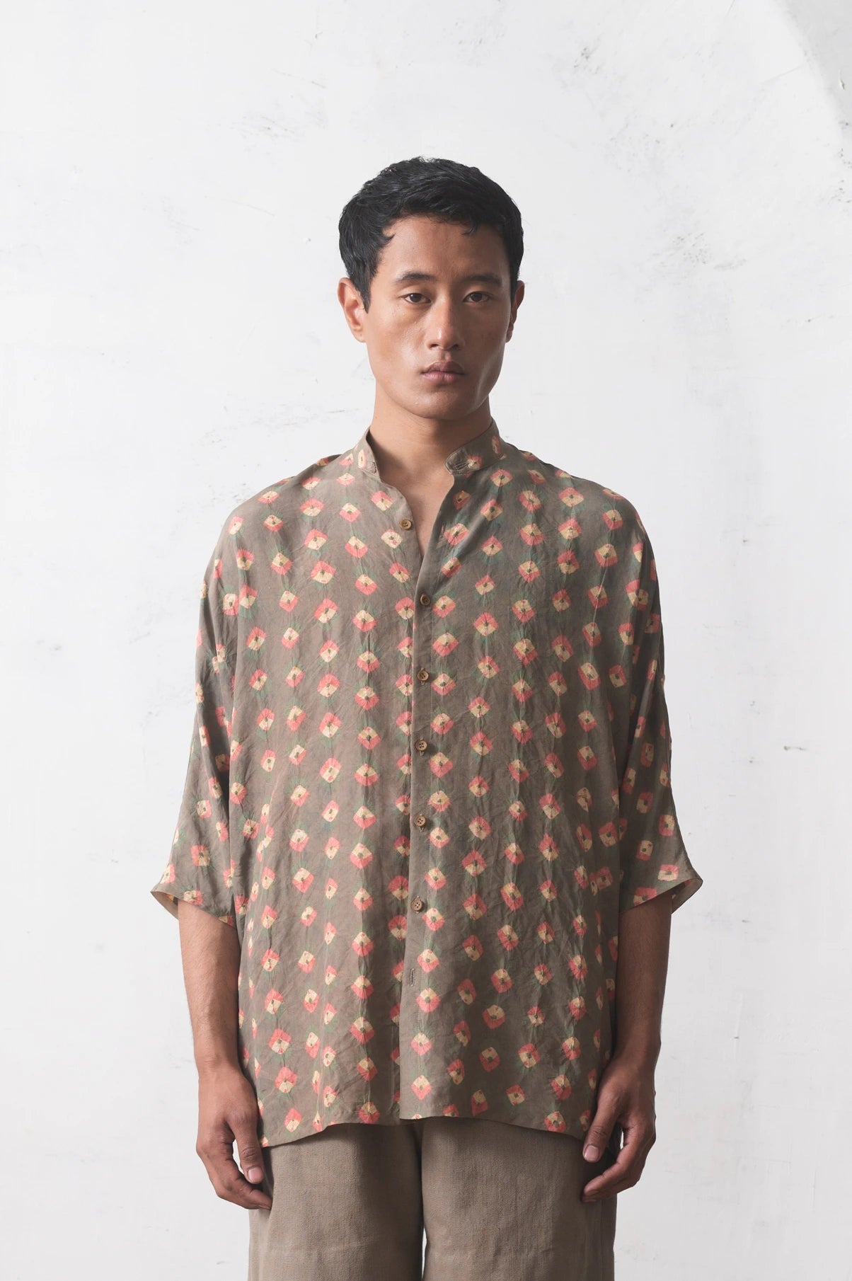 Man wearing a bandhani  shirt against a white background