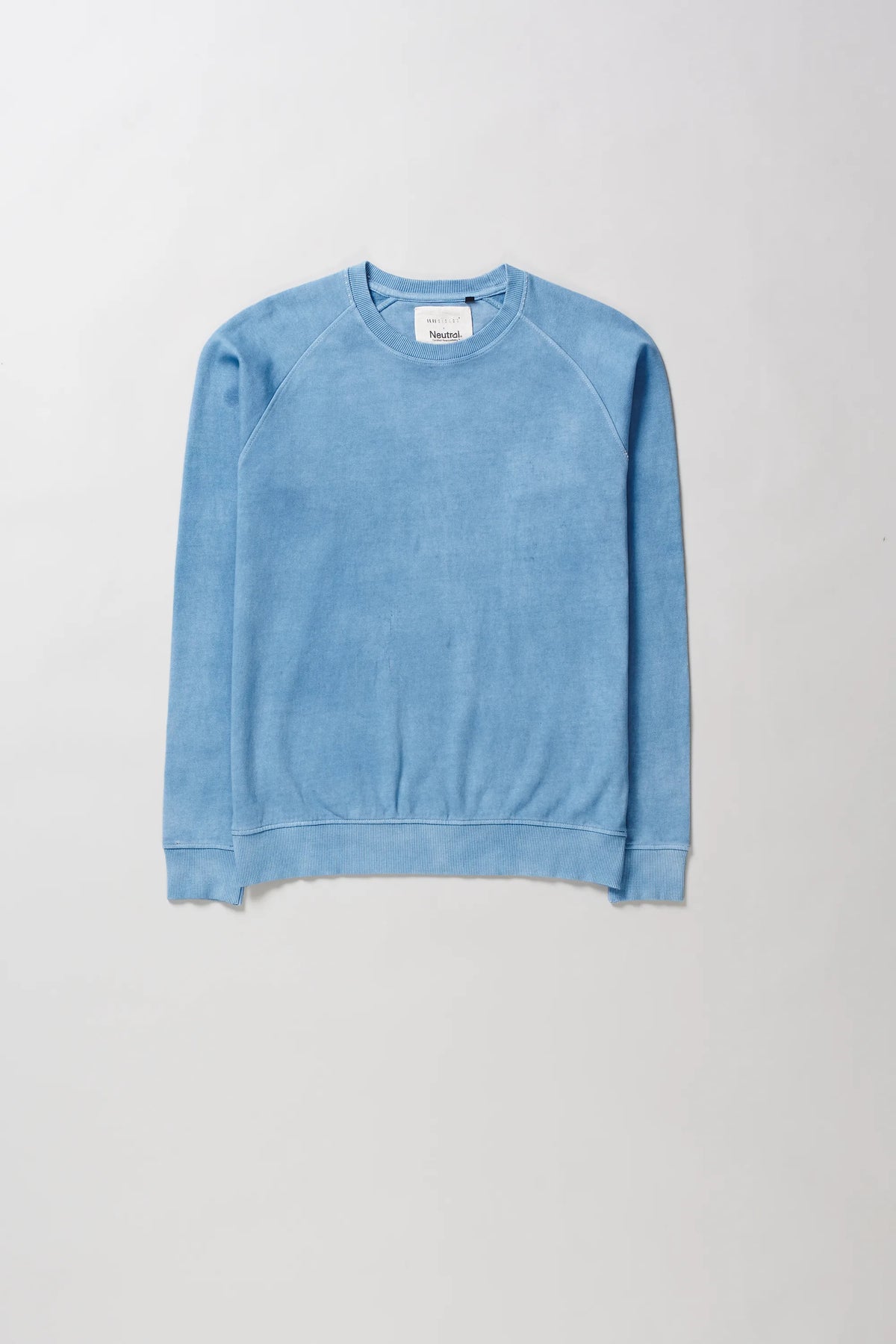 A light blue long-sleeve crewneck sweatshirt with raglan sleeves, laid flat against a neutral light grey background.