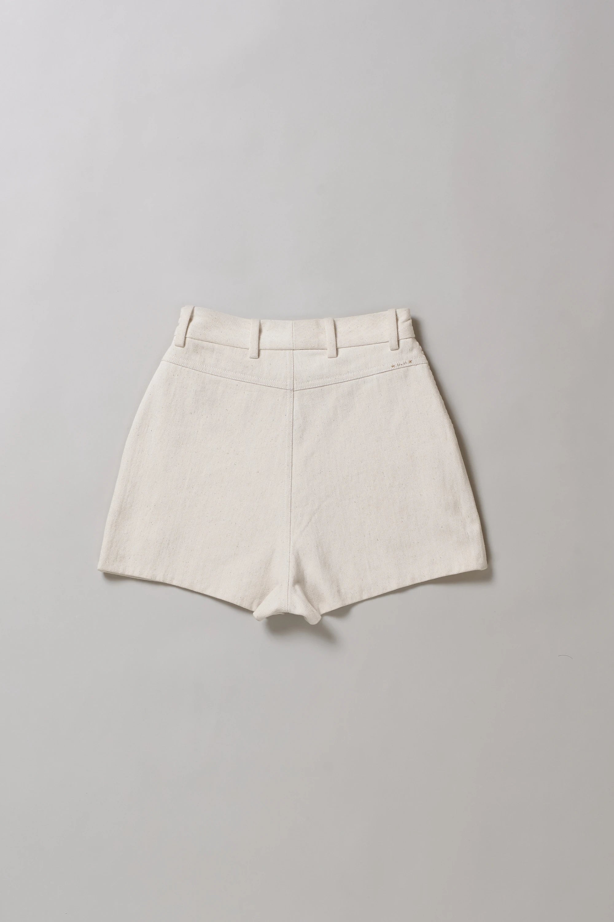 Back image of ecru shorts on a grey background