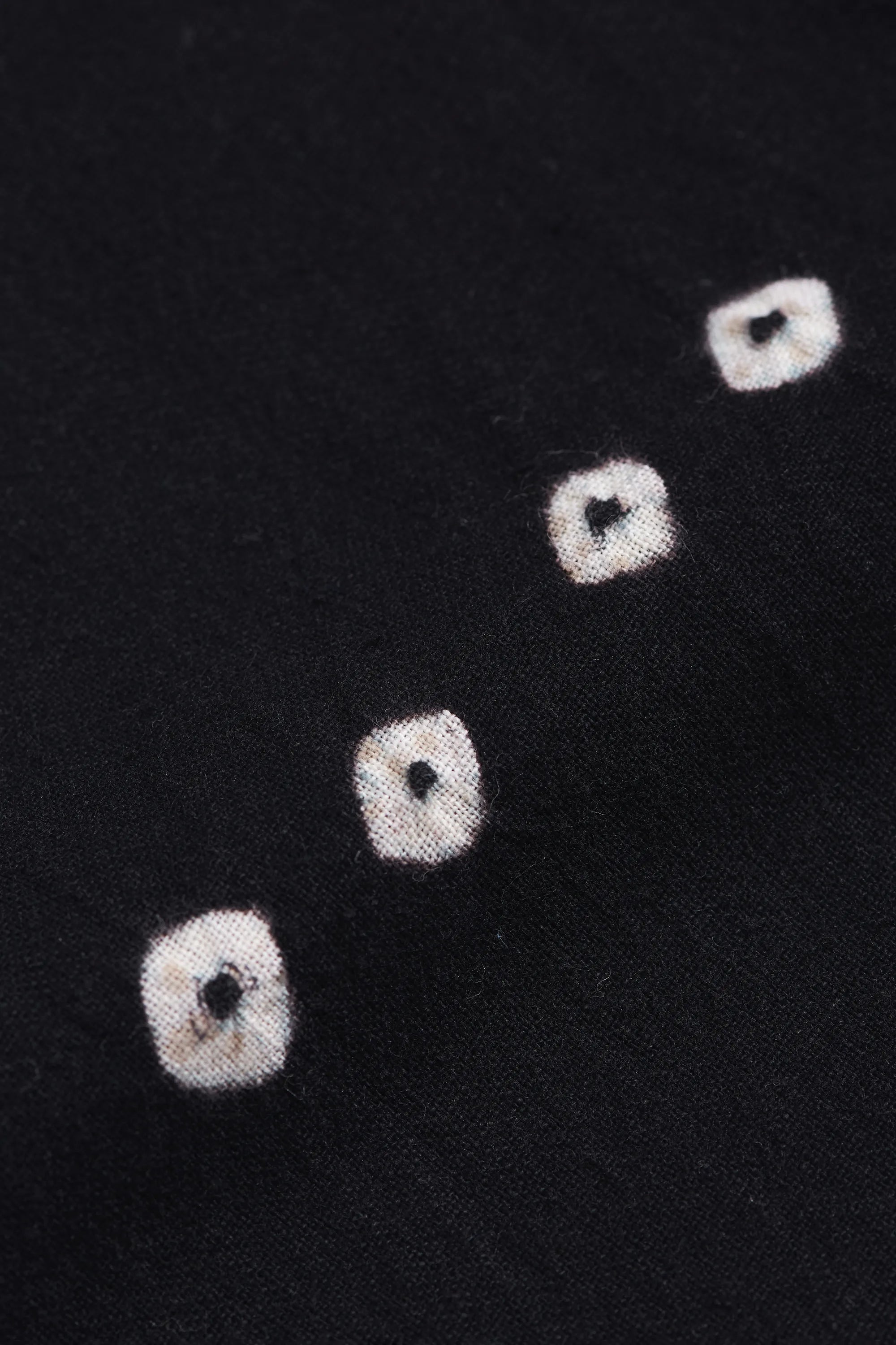 Close-up of black fabric with bandhani work