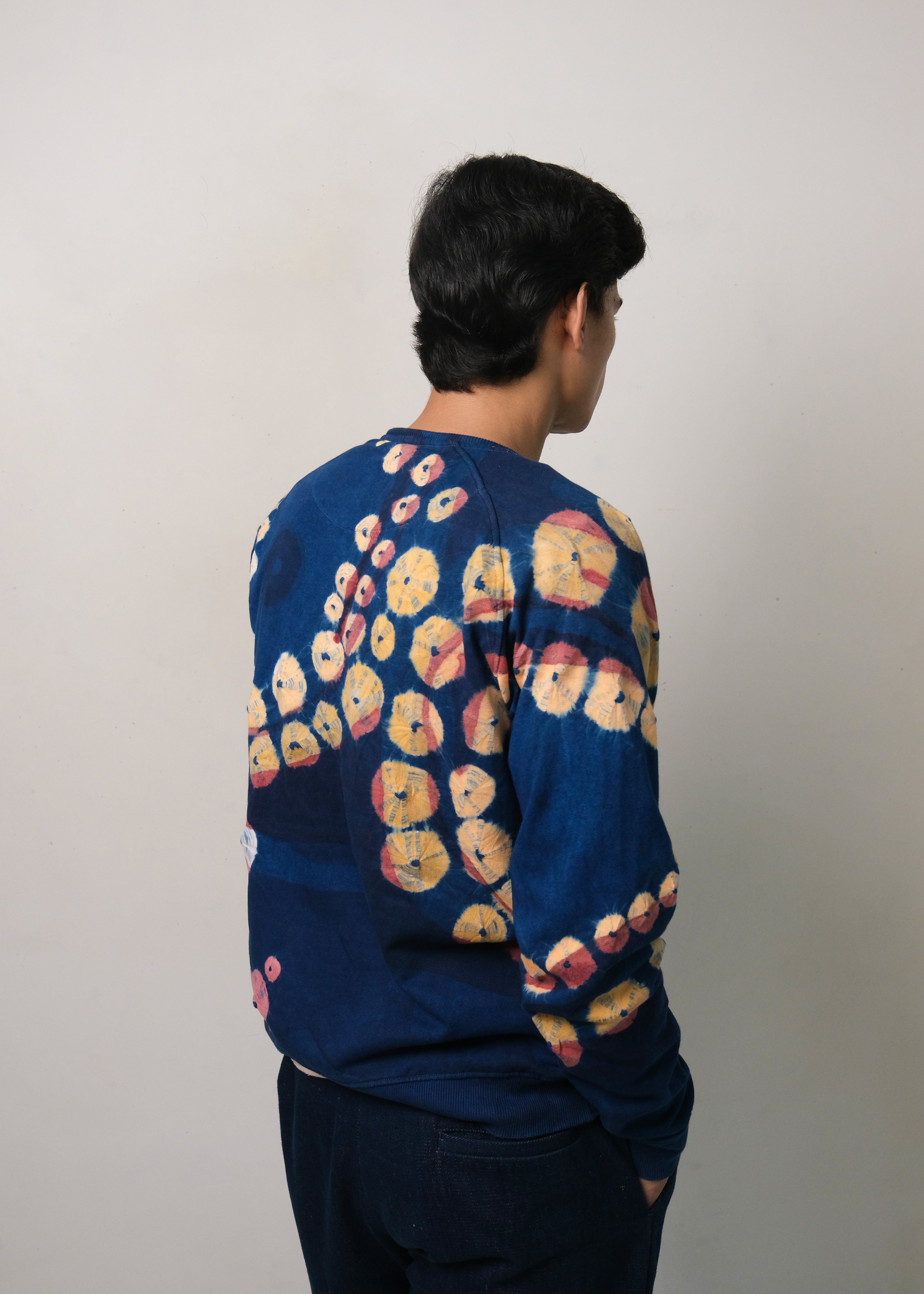 Back shot a man wearing of medium indigo handpaint bandhani sweatshirt