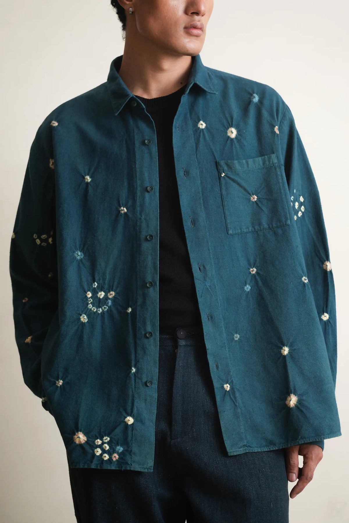 Bottle green shirt with bandhani and  buttons worn by a person on a light grey background