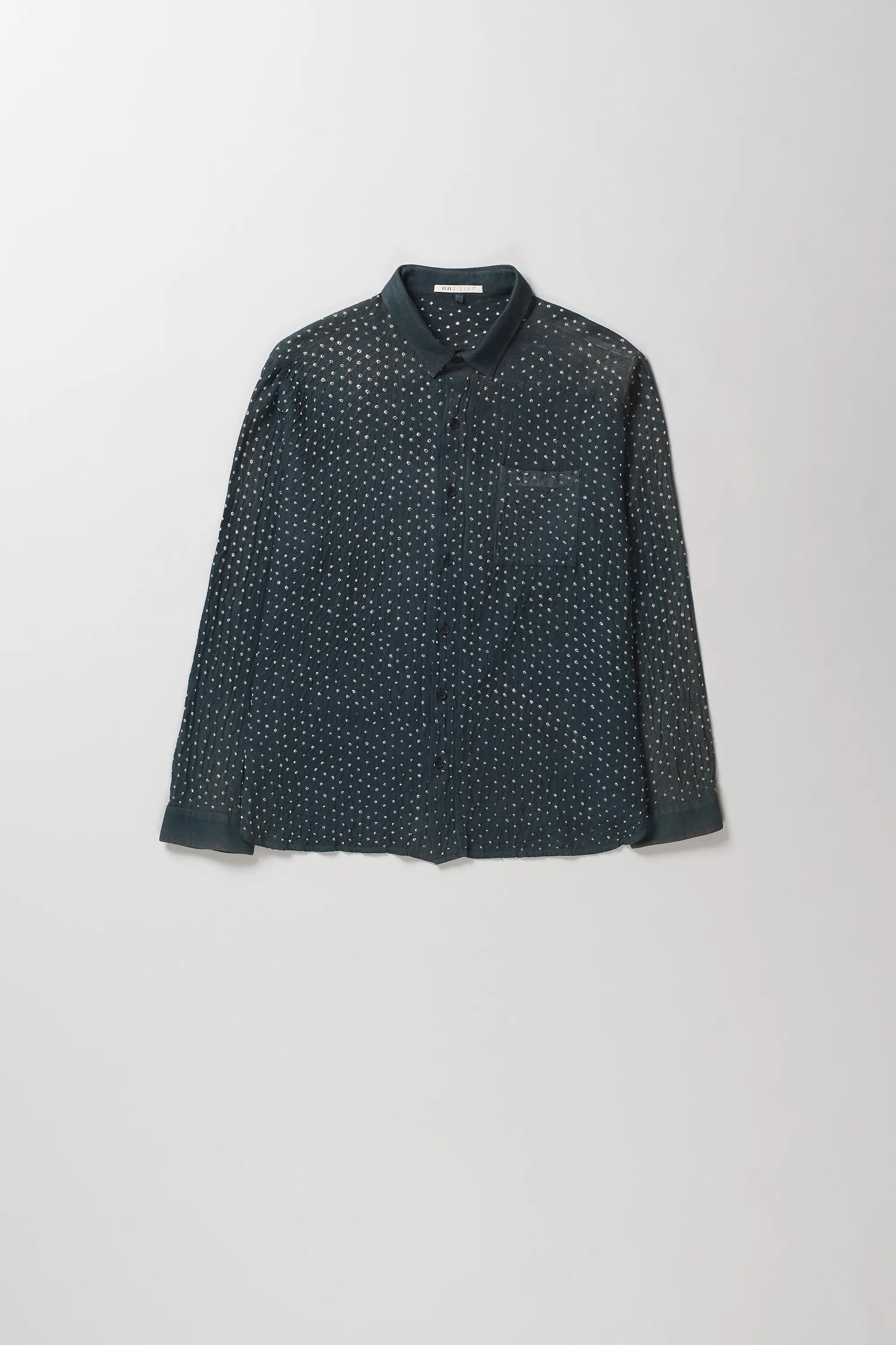 A midnight indigo long-sleeve button-up shirt with a dense white micro-dot bandhani pattern, displayed flat against a light gray background.