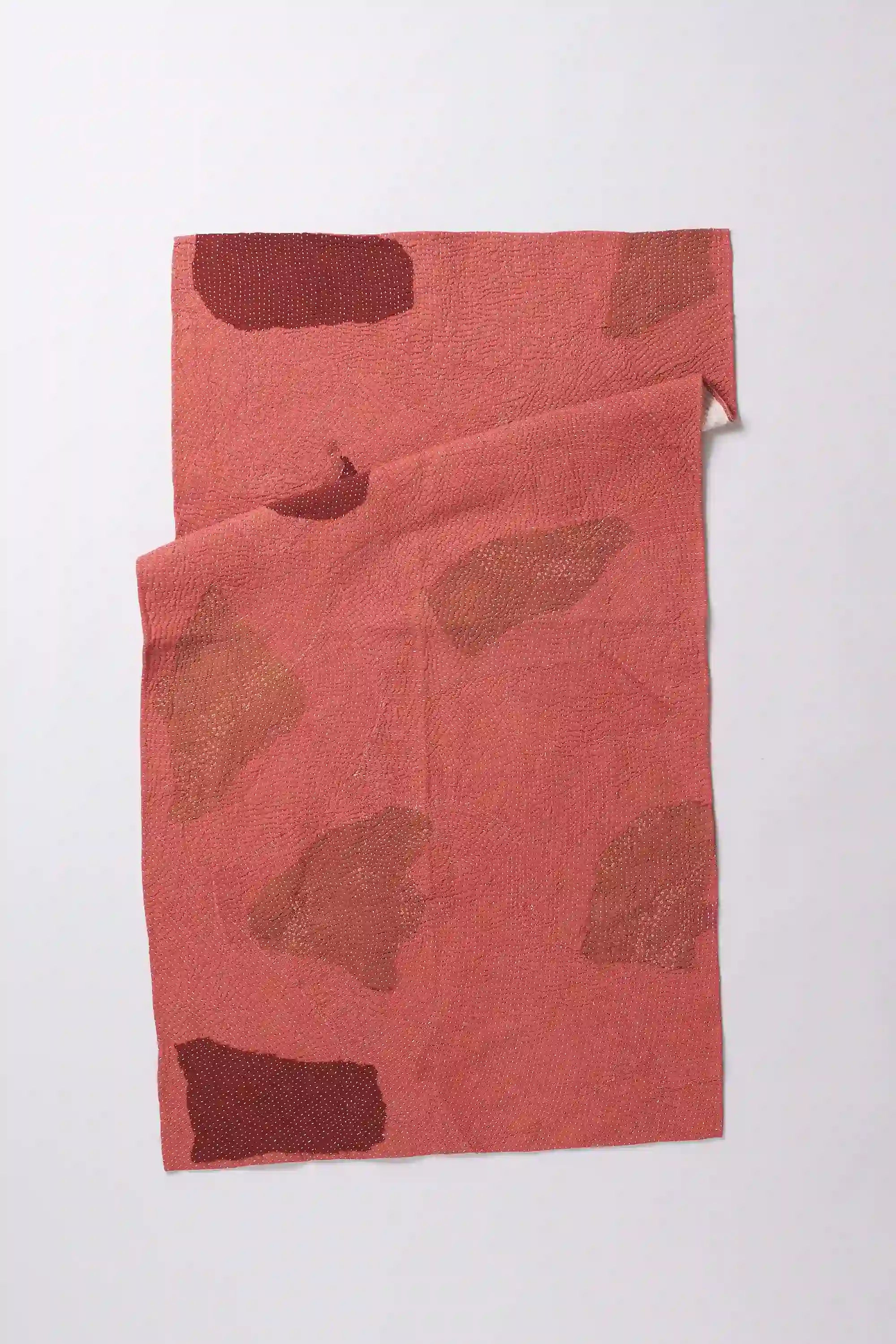 Folded quilt on light grey background