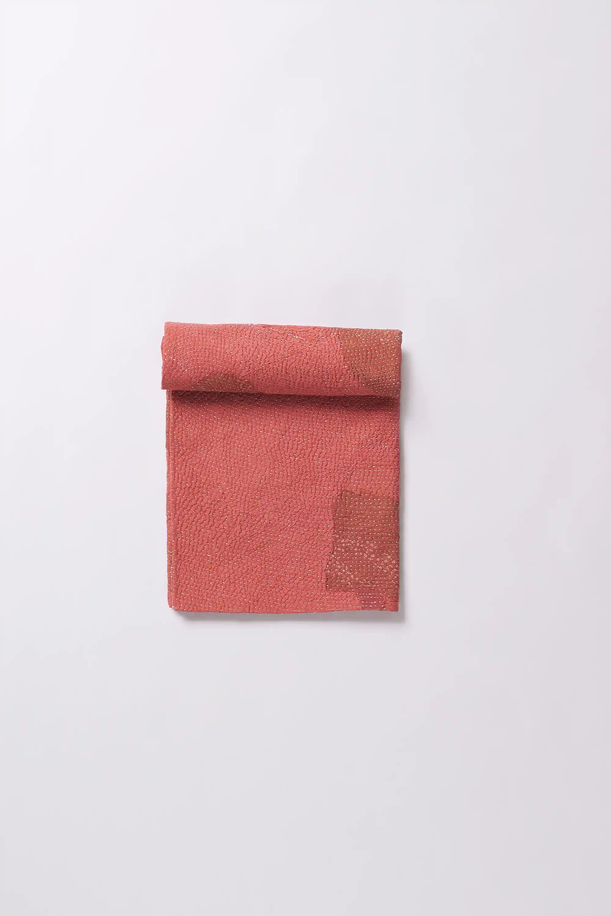 A  red quilt roll on a light grey background