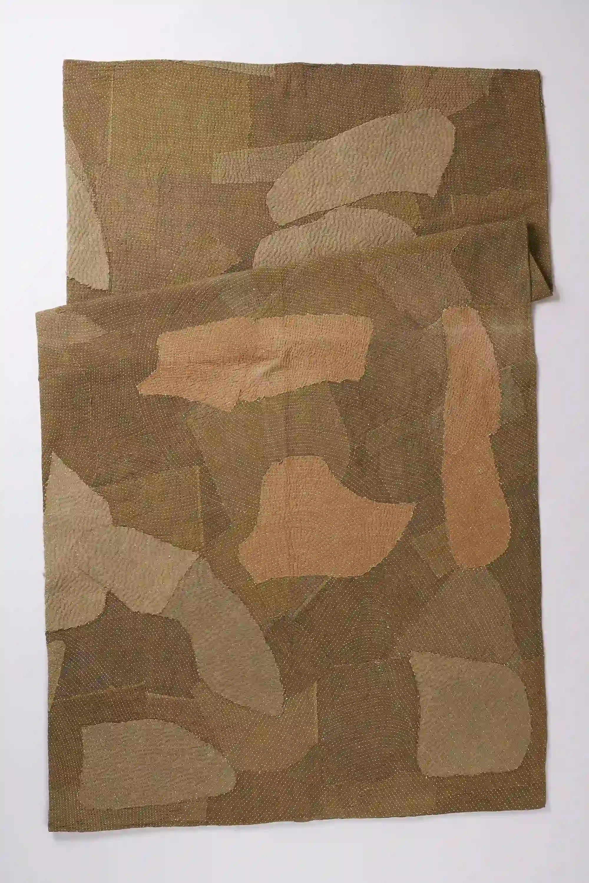 Folded quilt on light grey background