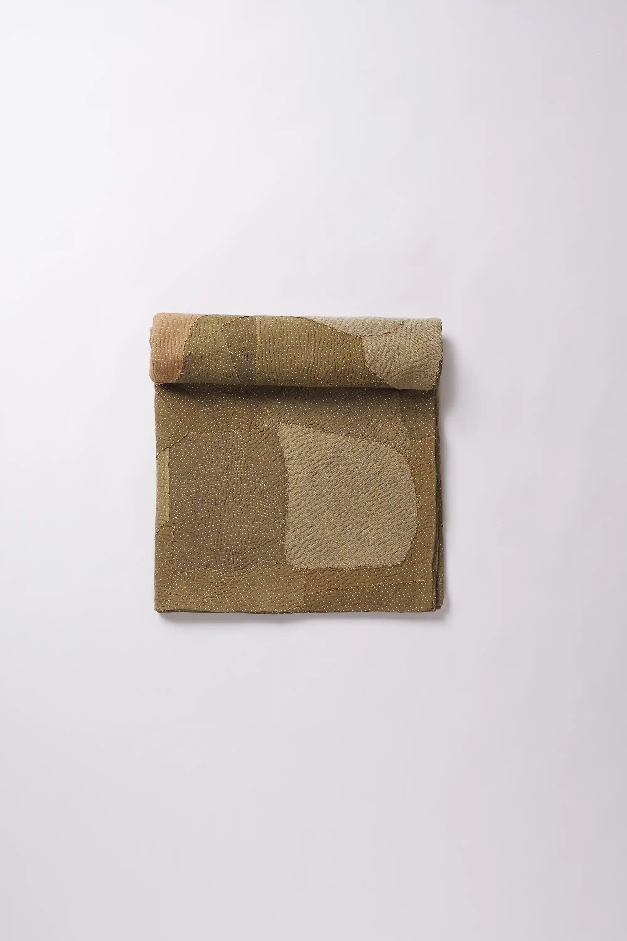 A  brick red quilt roll on a light grey background