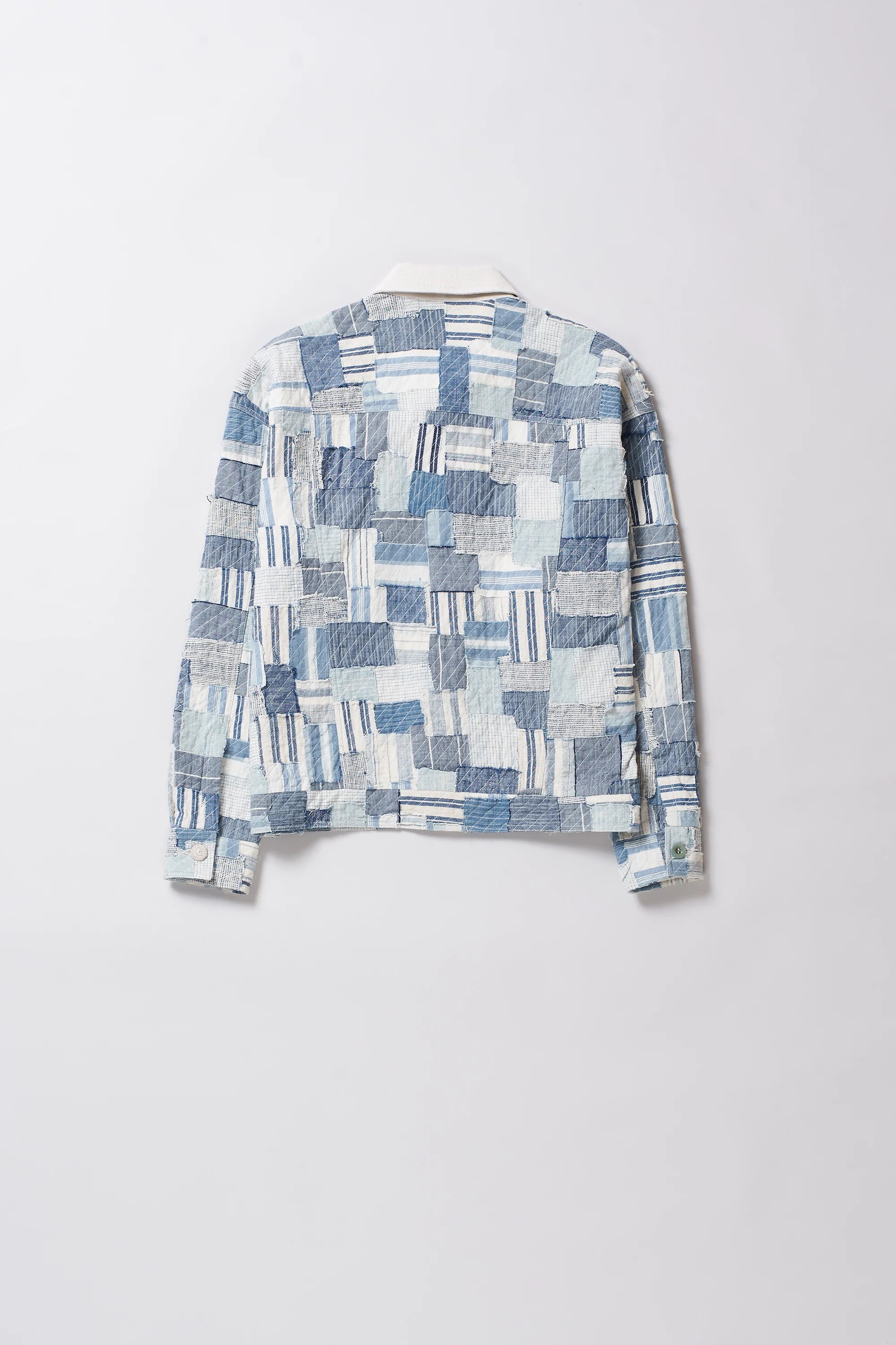 Blue and white patterned shirt on a light grey background
