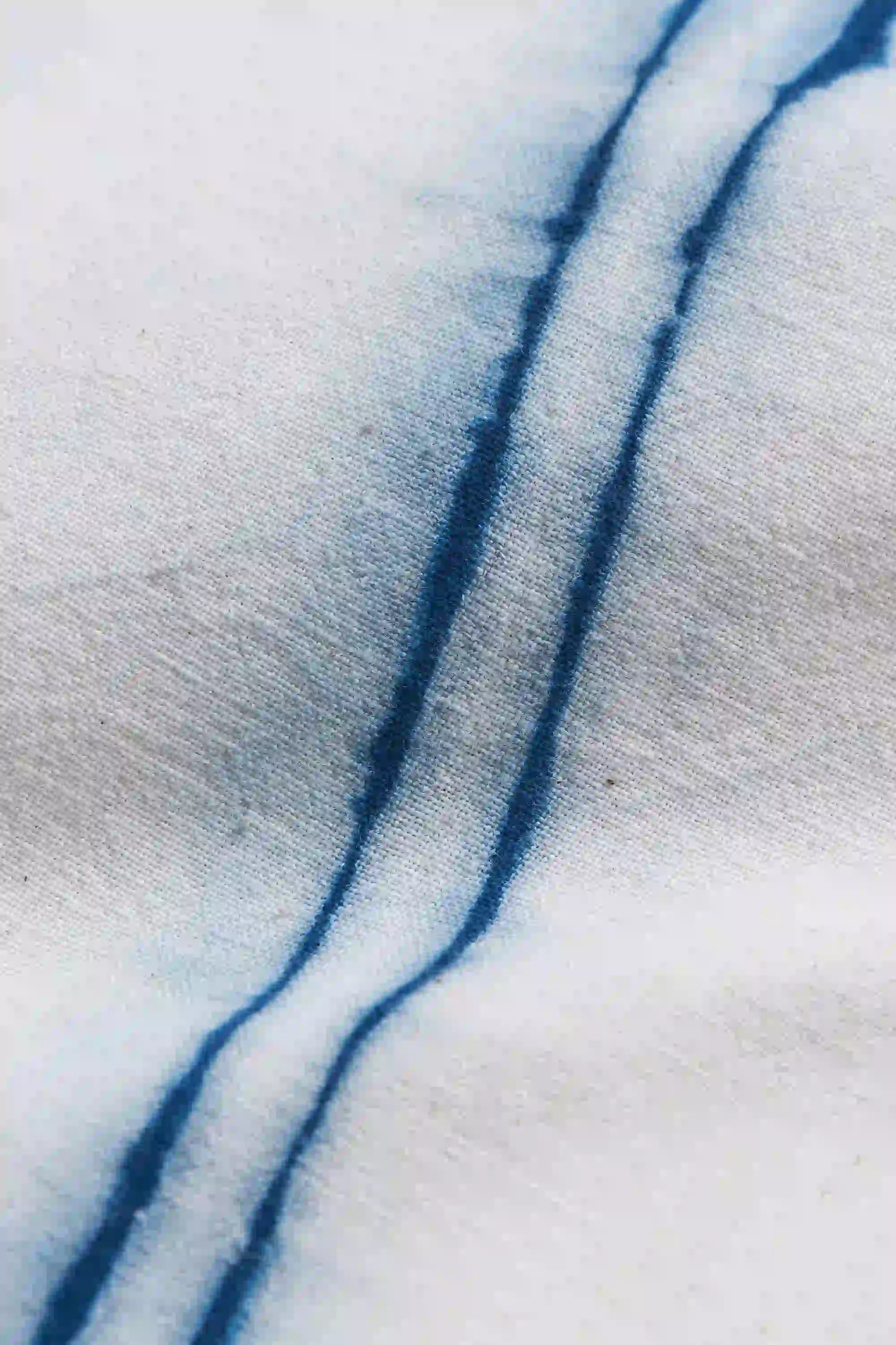 Close-up of blue streaks on a textured white surface