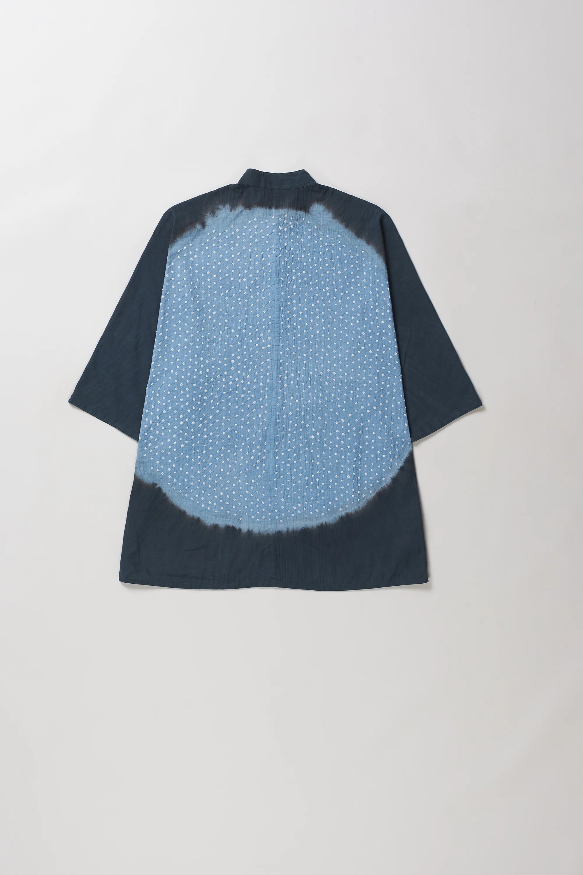 Back shot of midnight indigo and tie-dye short-sleeve shirt shown from the back, featuring a solid dark blue border and a lighter blue center with a white dotted pattern.
