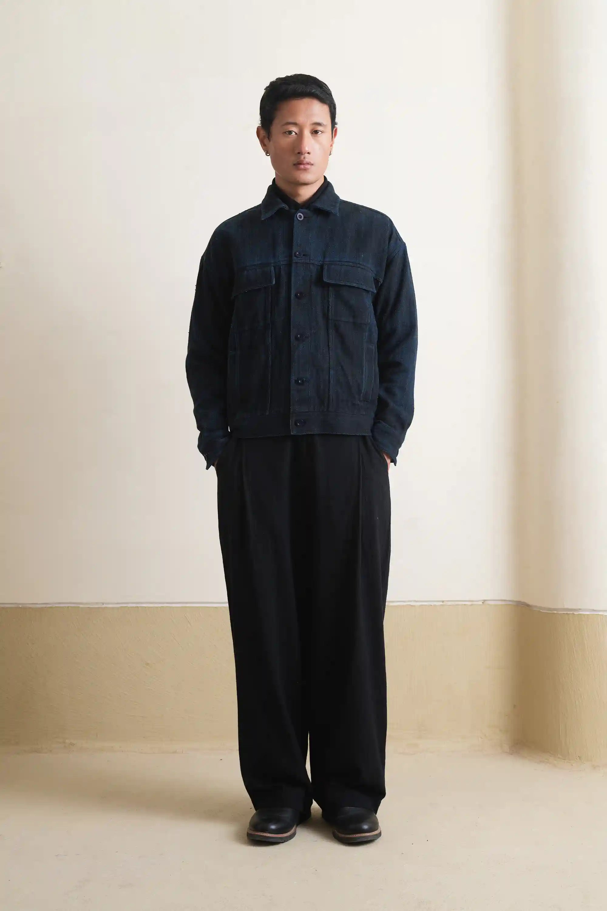 A man wearing black denim jacket with black pant