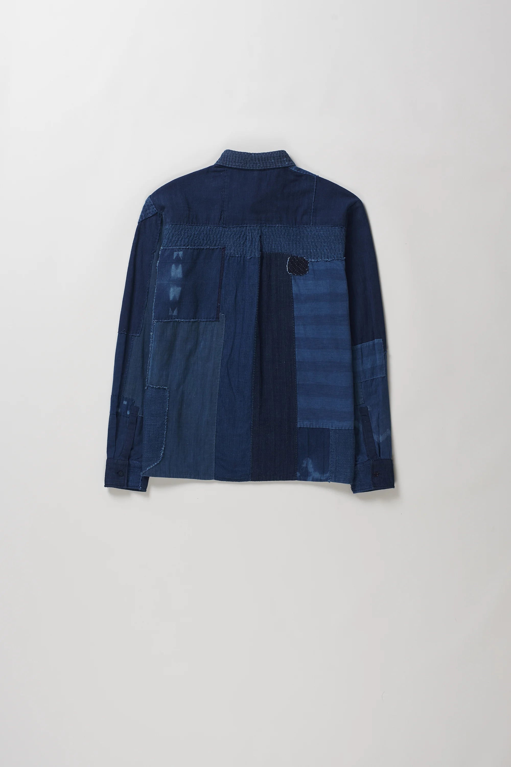 Back shot of long-sleeve button-up shirt with a dark blue patchwork design, displayed against a light grey background.