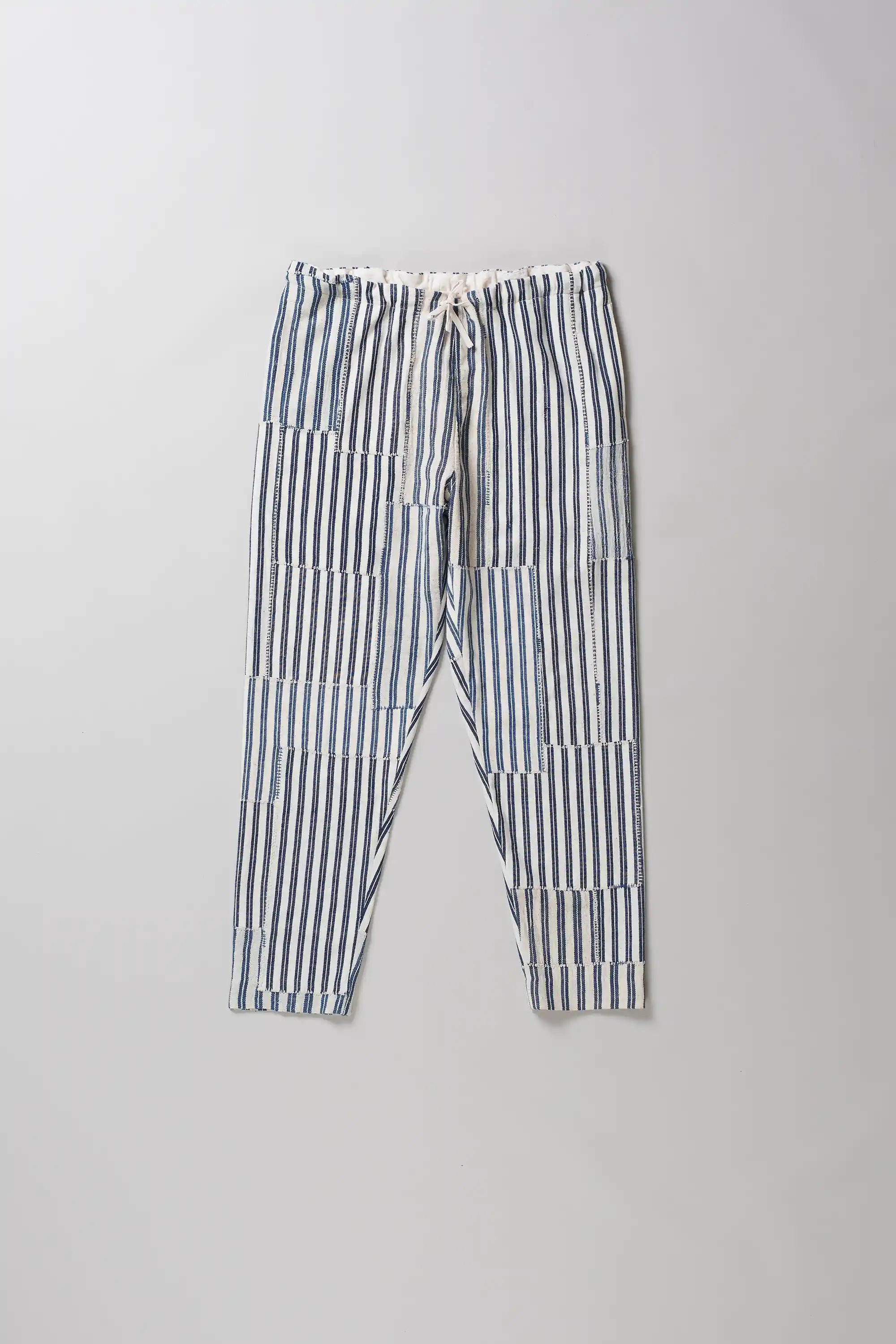 Front shot of pants with vertical blue and white stripes, laid flat on a light grey background.