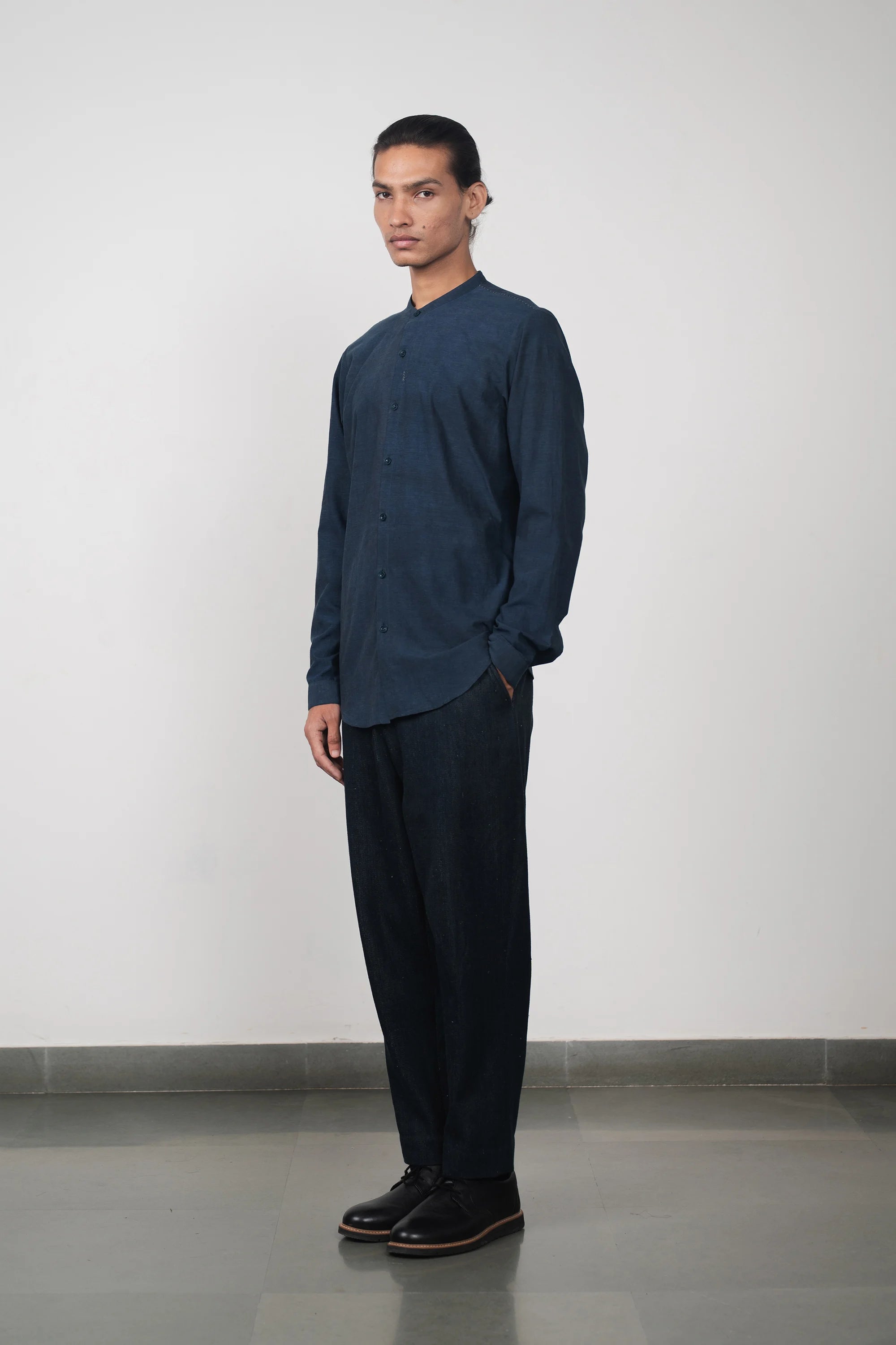 A man wearing estate blue shirt