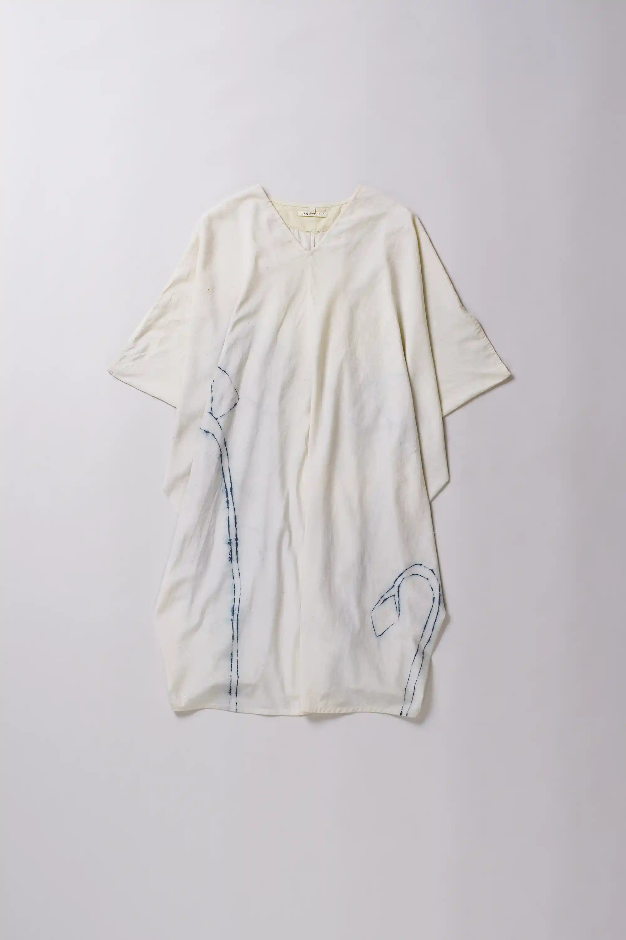 White dress with blue embroidery on a white background