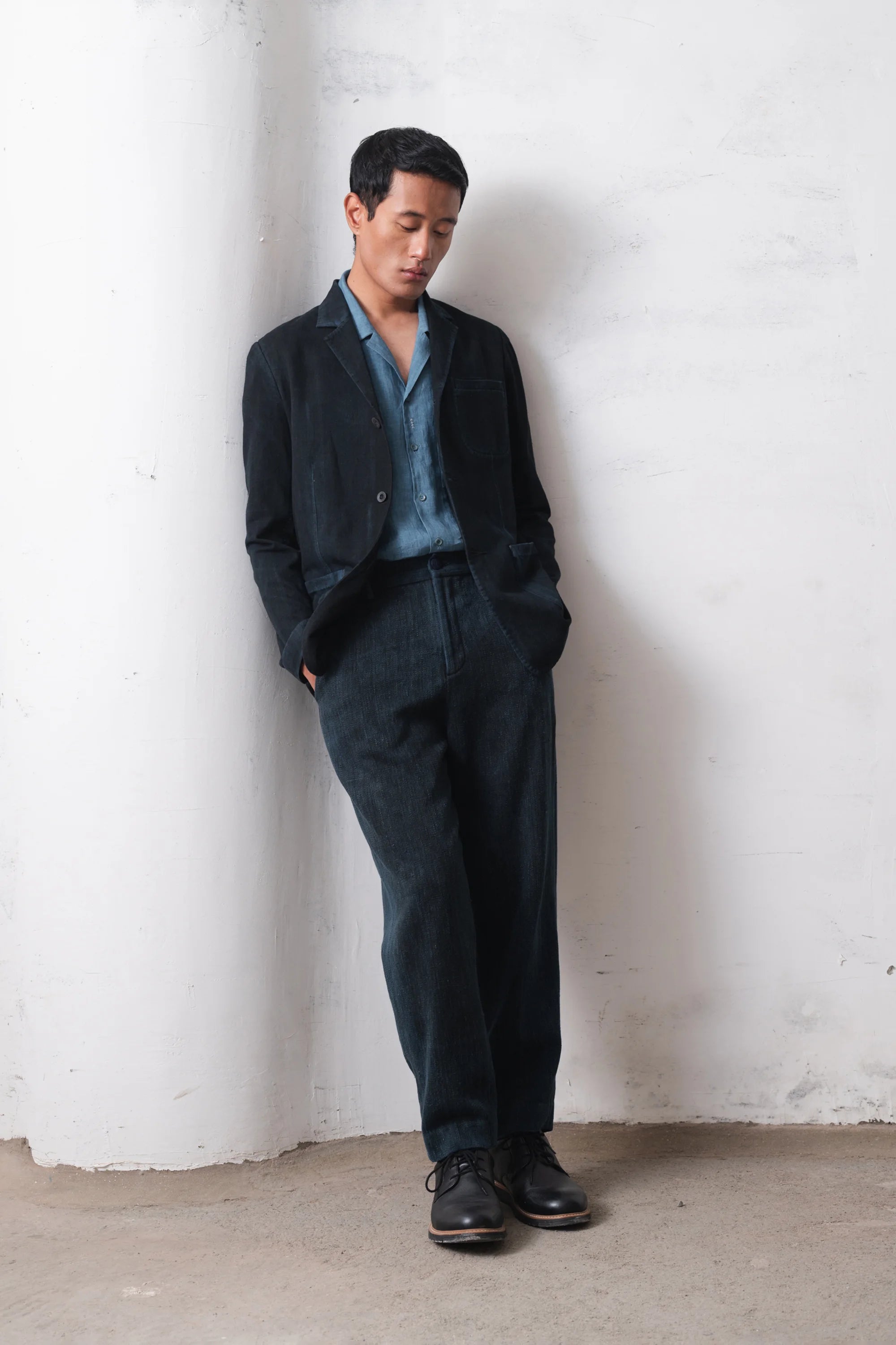 Man wearing a black jacket  with light blue shirt